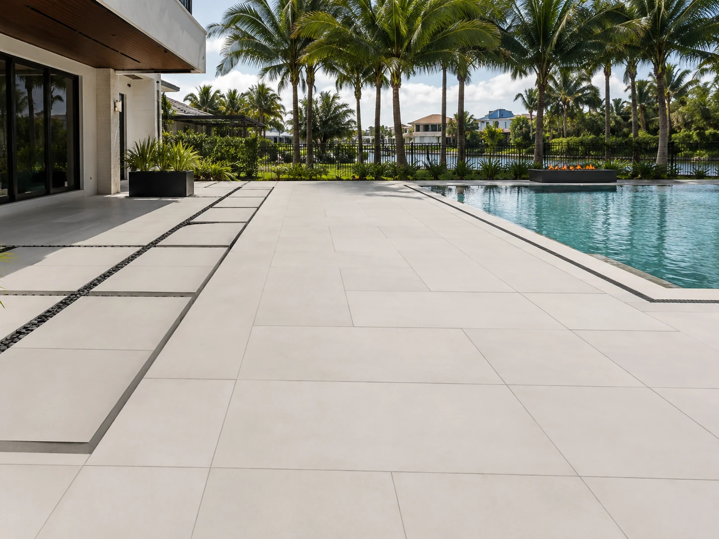 Large-format pavers and slab-style surfaces around a modern Florida pool patio
