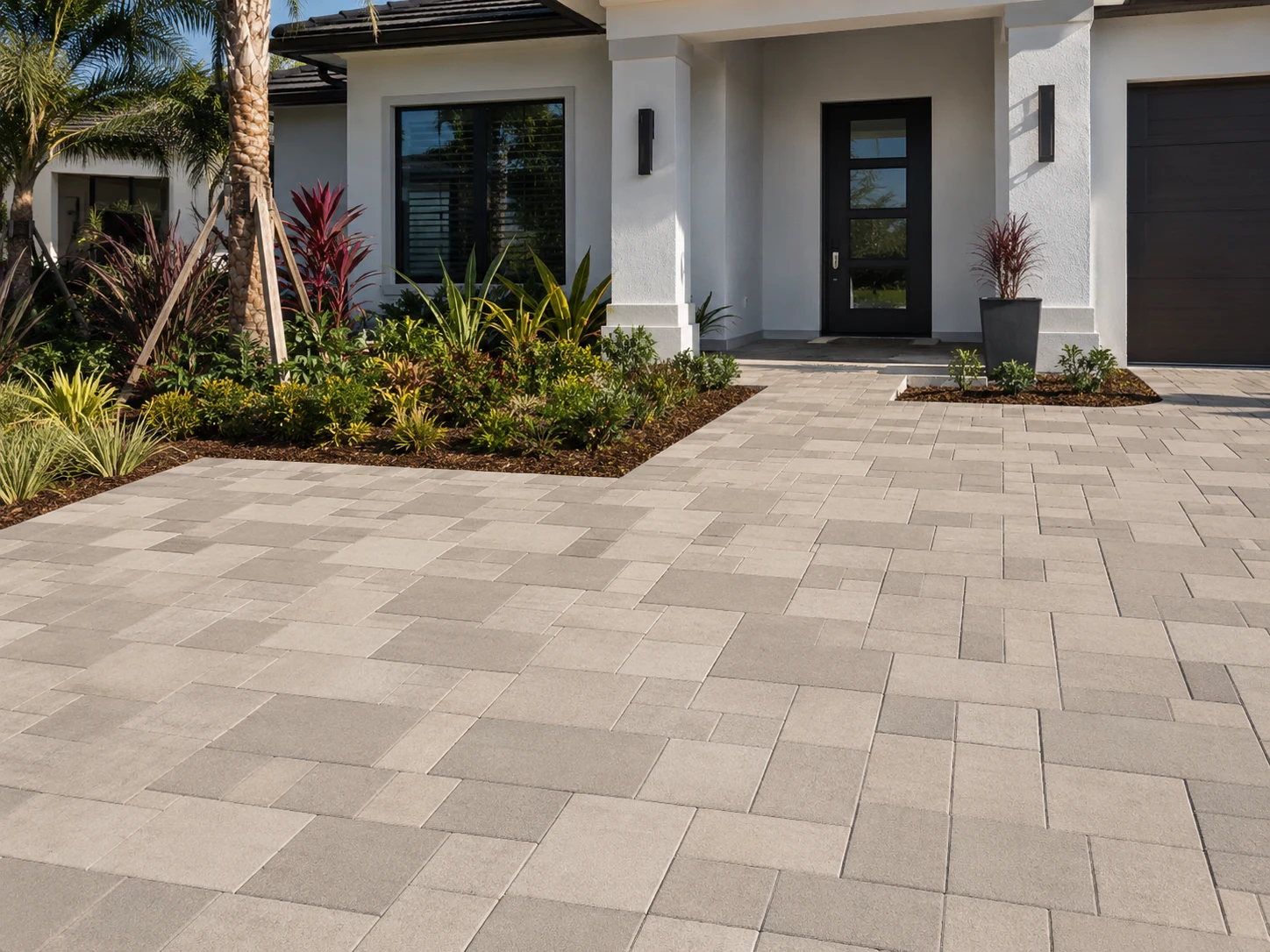 Three-piece modular concrete paver driveway with mixed-size rectangular units at a modern home