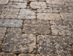 Uneven worn paver surface before repair